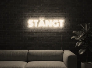 Neonskylt «STÄNGT» i varmvit LED-neon, monterad på vägg